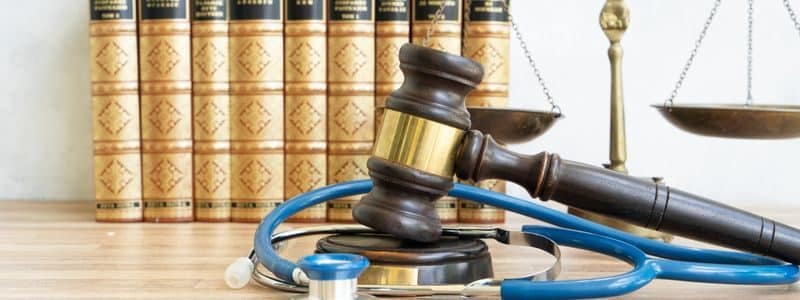 Books, medical stethoscope, and Gavel representing a corporate integrity agreement.