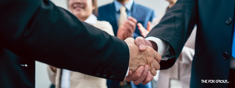 A HIPAA business associate shakes hands with the CEO of a covered entity to signify their agreement.